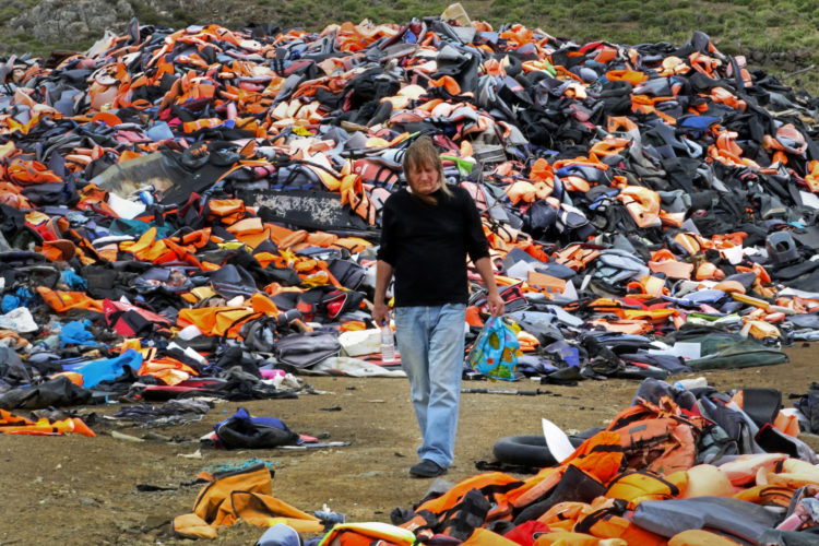 LESVOS, GREECE (EU) 06-04-2017: Eric Kempson walks through a landfill known as the "Lifejacket Graveyard," a dumping ground for thousands of discarded life jackets and rubber rafts used by refugees and their smugglers to get to Lesvos, Greece. Eric and his wife Philippa have helped thousands of refugees since the migration crisis began in 2015, and have worked tirelessly to advocate and assist refugees fleeing war-torn Syria and other countries in conflict.