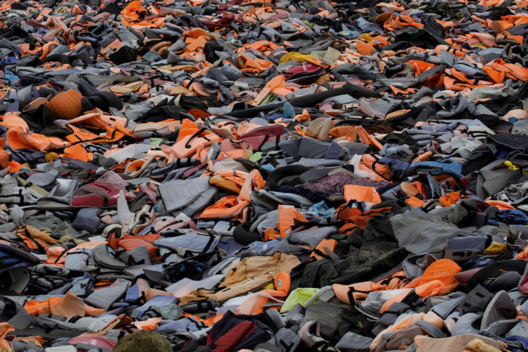 LESVOS, GREECE (EU) 06-04-2017: The "Lifejacket Graveyard," a dumping ground for thousands of discarded life jackets and rubber rafts used by refugees and their smugglers to get to Lesvos, Greece, has become a symbol of the thousands of refugees who have sought asylum in Greece (EU), including many who drowned.