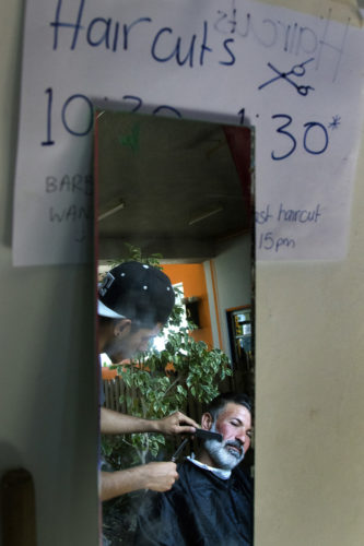 LESVOS, GREECE  06/06/2017: A man gets a shave and haircut at the "One Happy Family Community Center" in Lesvos, a migrant shelter for people fleeing from wars and crises in the Middle-East and Northern Africa. The non-profit was been started in February 2017 by Swisscross, with many partner organizations on the ground, and the help of countless young volunteers from all around Europe and the inhabitants of the refugee camps. The center is located near the two camps on the island, and overlooks the Med  provides a welcoming environment with a wide range of assistance for refugees, such as classes, a gym, internet cafe, and more.