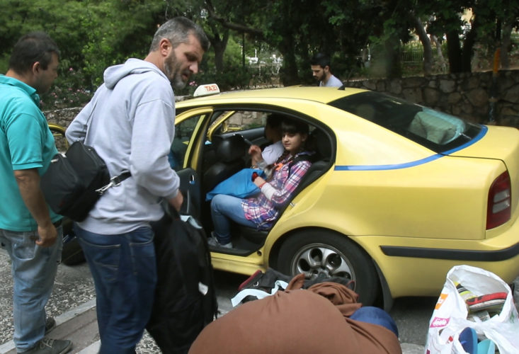 ATHENS, GREECE (EU) 05-29-2017: Hosem Al Rahmoun loads his family and their belongings into an awaiting taxi. Today his family is moving into their new apartment after living in a refugee squat in an abandoned school building in Athens for the past few months. They are being sponsored by two sisters in New York who raised money for them through HumanWire's Tent-to-Home Project.