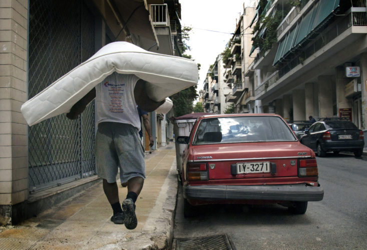 ATHENS, GREECE (EU) 05-30-2017 : A man carries a mattress for a refugee family relocated in Athens.