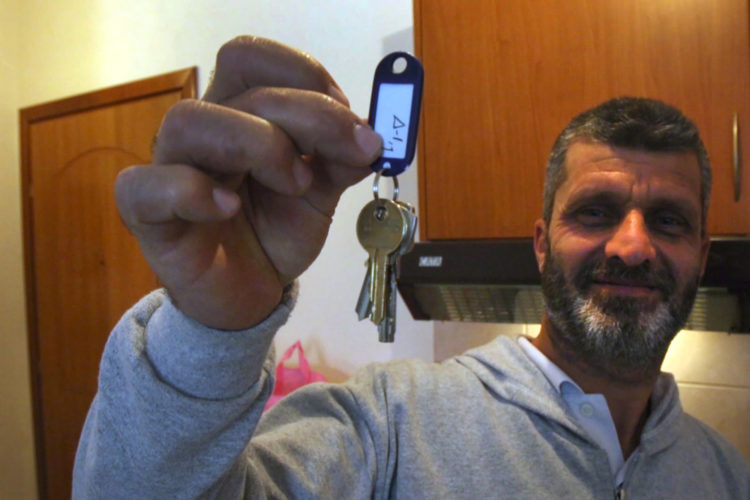 ATHENS, GREECE (EU) 05-29-2017: Hosem Al Rahmoun proudly holds-up the keys to his family's new apartment after living huddled in a refugee squat in an abandoned school building in Athens for the past few months. They are being sponsored by two sisters in New York who raised money for them through HumanWire's Tent-to-Home Project, the new apartment is a welcome relief from the refugee camps.