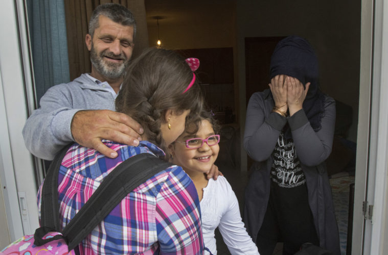 ATHENS, GREECE (EU) 05-29-2017: Hosem and Manar Al Rahmoun share a happy moment with daughters Sara and Hala in their new apartment in Athens after living in a refugee squat in an abandoned school building for the past few months. They are being sponsored by two sisters in New York who raised money for them through HumanWire's Tent-to-Home Project, the new apartment is a welcome relief from the refugee camps. The family was giddy over their good fortune.