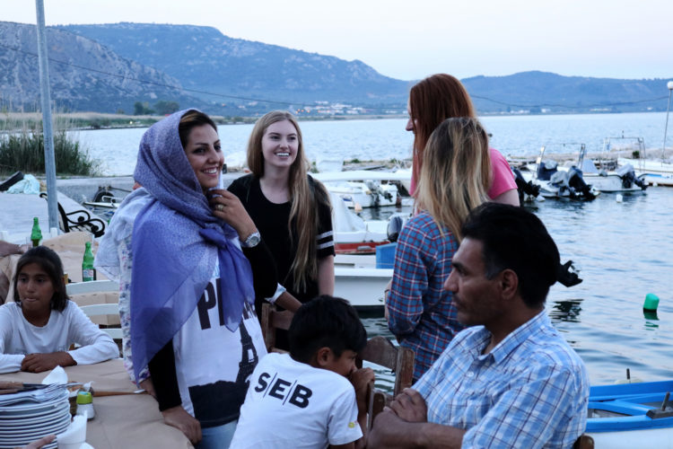 LESVOS, GREECE (EU)  06/03/2017: Refugees and volunteers from the nearby Moria Refugee camp socialize before dinner at "Home for All," the Mytileni restaurant that serves dinner each night to refugees for free on the island of Lesvos. A gathering point for donations of goods and emotional support, Home is run by restaurant owners Nikos and Katerina Katsouris, and has become an important gathering point for donations of goods and emotional support, for refugees.