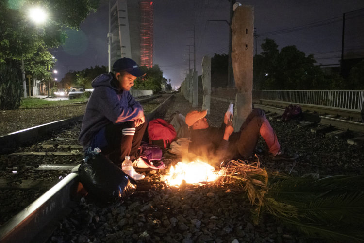 GUADALAJARA, MEXICO   07/13/2017  A group of Honduran men make campfire along the railroad tracks in Guadalajara, where wild dogs and gang members lurk in the shadows, as they continue on the journey to the U.S. border. After leaving the nearby FM4 shelter, the men walked along the railroad tracks to a position where they wait to jump on board La Bestia, the moving freight train known as The Beast. According to the Migration Policy Institute (MPI), a half a million Central American immigrants ride atop La Bestia during their long and perilous journey through Mexico to the U.S. The migrants often must latch onto the moving freights, which run along multiple lines, carry products north for export, and must ride atop the moving trains, facing physical dangers that range from amputation to death if they fall or are pushed. Beyond the dangers of the trains themselves, Central American migrants are subject to extortion and violence at the hands of the gangs and organized-crime groups that control the routes north.The migrant shelter provides a clean and safe place for migrants to rest, wash and eat, while volunteers from non-governmental organizations offer clean clothes, medical attention, and free legal and psychological counseling. M4 Paso Libre was started by a group of students in 2007 and opened its first kitchen and day shelter in 2010. The nonprofit is a member of the Office of the United Nations High Commissioner for Refugees (UNHCR), assists approximately 8,000 migrants each year, and relies on regular donations and hundreds of volunteers to support the migrants who pass through.