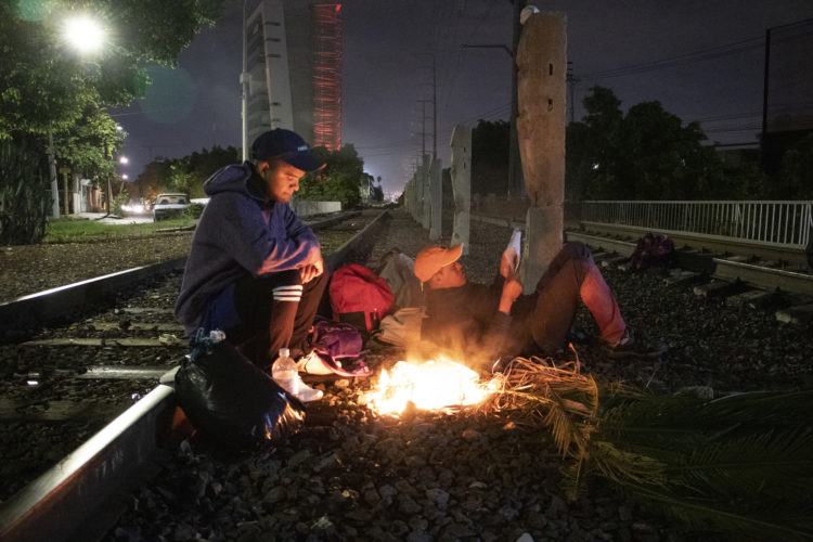 GUADALAJARA, MEXICO   07/13/2017  A group of Honduran men make campfire along the railroad tracks in Guadalajara, where wild dogs and gang members lurk in the shadows, as they continue on the journey to the U.S. border. After leaving the nearby FM4 shelter, the men walked along the railroad tracks to a position where they wait to jump on board La Bestia, the moving freight train known as The Beast. 

According to the Migration Policy Institute (MPI), a half a million Central American immigrants ride atop La Bestia during their long and perilous journey through Mexico to the U.S. The migrants often must latch onto the moving freights, which run along multiple lines, carry products north for export, and must ride atop the moving trains, facing physical dangers that range from amputation to death if they fall or are pushed. Beyond the dangers of the trains themselves, Central American migrants are subject to extortion and violence at the hands of the gangs and organized-crime groups that control the routes north.



The migrant shelter provides a clean and safe place for migrants to rest, wash and eat, while volunteers from non-governmental organizations offer clean clothes, medical attention, and free legal and psychological counseling. 

M4 Paso Libre was started by a group of students in 2007 and opened its first kitchen and day shelter in 2010. The nonprofit is a member of the Office of the United Nations High Commissioner for Refugees (UNHCR), assists approximately 8,000 migrants each year, and relies on regular donations and hundreds of volunteers to support the migrants who pass through.