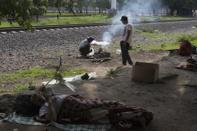 GUADALAJARA, MEXICO  07/14/2017: A group of Honduran migrants make camp along the railroad tracks in Guadalajara, roughly the midway between Central American and the U.S., along the route of Mexican freight trains that are utilized by U.S.- bound migrants to more quickly traverse the length of Mexico, also known as La Bestia and El tren de los desconocidos. This mode of travel is extremely dangerous and illegal.  

According to the Migration Policy Institute (MPI), a half a million Central American immigrants ride atop La Bestia during their long and perilous journey through Mexico to the U.S. The migrants often must latch onto the moving freights, which run along multiple lines, carry products north for export, and must ride atop the moving trains, facing physical dangers that range from amputation to death if they fall or are pushed. Beyond the dangers of the trains themselves, Central American migrants are subject to extortion and violence at the hands of the gangs and organized-crime groups that control the routes north.