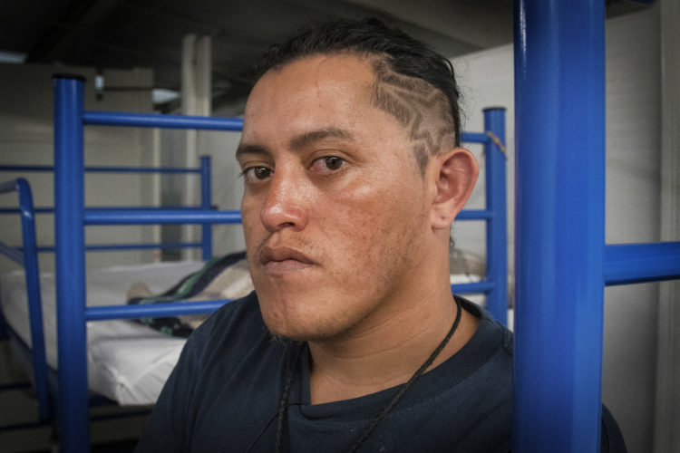 GUADALAJARA, MEXICO   07/13/2017  Mario, a migrant from Honduras, has the stars and stripes from the national Honduran flag shaved into his hair. He had been staying in the FM4 Paso Libre shelter in Guadalajara, and now he's preparing to leave FM4 to continue on the journey to the U.S. border.  After leaving FM4 at night, the men walked along the railroad tracks to a position where they can jump on board La Bestia, the moving freight train known as The Beast.