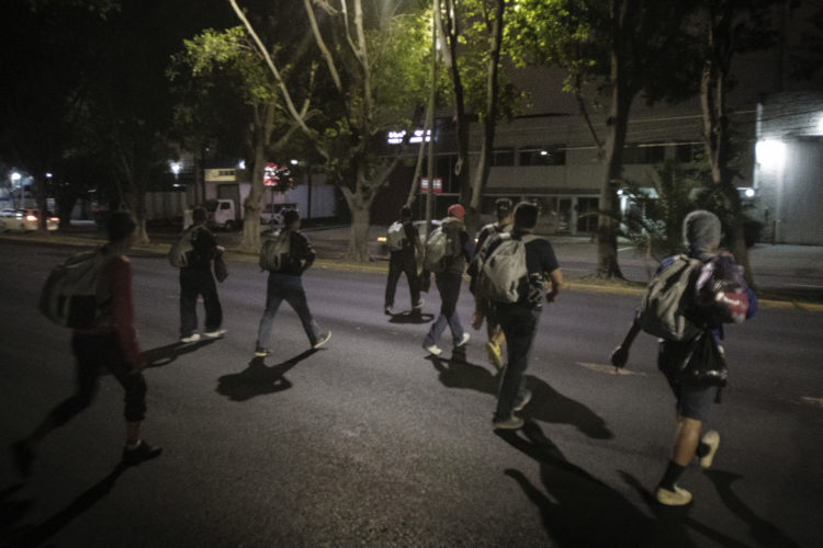 GUADALAJARA, MEXICO   07/13/2017  A group of Honduran men walk through the streets of Guadalajara heading towards the  railroad tracks to continue on the journey to the U.S. border. After leaving the nearby FM4 shelter, the men walked along the railroad tracks to a position where they can jump on board La Bestia, the moving freight train known as The Beast.