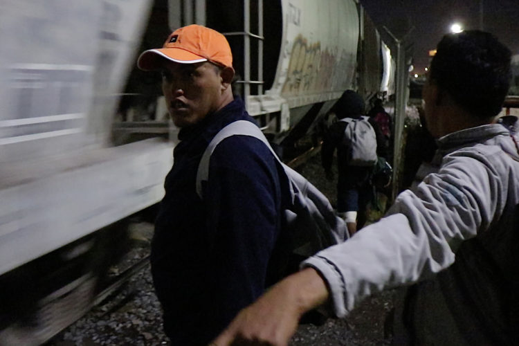 GUADALAJARA, MEXICO   07/13/2017  A group of Honduran men take positions along the railroad tracks preparing to jump on board the fast moving freight train known as The Beast. The men wait for a slow down and then run on the rocky gravel alongside the moving train looking for a boxcar that has a ladder to grab ahold of and hoist themselves to board the train. La Bestia (the Beast) is utilized by U.S. bound migrants to more quickly, and at no cost, to traverse the length of Mexico. This mode of travel is extremely dangerous and illegal.  

According to the Migration Policy Institute (MPI), a half a million Central American immigrants ride atop La Bestia during their long and perilous journey through Mexico to the U.S. The migrants often must latch onto the moving freights, which run along multiple lines, carry products north for export, and must ride atop the moving trains, facing physical dangers that range from amputation to death if they fall or are pushed. Beyond the dangers of the trains themselves, Central American migrants are subject to extortion and violence at the hands of the gangs and organized-crime groups that control the routes north.



The migrant shelter provides a clean and safe place for migrants to rest, wash and eat, while volunteers from non-governmental organizations offer clean clothes, medical attention, and free legal and psychological counseling. 

M4 Paso Libre was started by a group of students in 2007 and opened its first kitchen and day shelter in 2010. The nonprofit is a member of the Office of the United Nations High Commissioner for Refugees (UNHCR), assists approximately 8,000 migrants each year, and relies on regular donations and hundreds of volunteers to support the migrants who pass through.