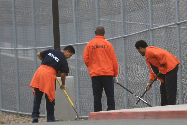 SAN DIEGO, CA  07/17/2019: Detainees cleanup the grounds outside the Otay Mesa Detention Center (ICE) in San Diego, just north of the Mexico border in Tijuana. Detainees are often given an opportunity to work at the detention center, jobs can range from doing exterior weed landscaping to sanitary duties to kitchen staff duties. In February 2019, more than 70 detainees signed a letter decrying conditions at the facility, alleging medical neglect, safety issues, and discrimination, according to Freedom for Immigrants. The detainees also claimed that  complaints were not being heard at the facility. CoreCivic, the contractor that operates the facility, denied the allegations made about conditions.Otay Mesa is a 350,000-square-foot detention facility with 1,492 total beds, surrounded by a barbed wire perimeter fence, and looks very much like a low-security prison.