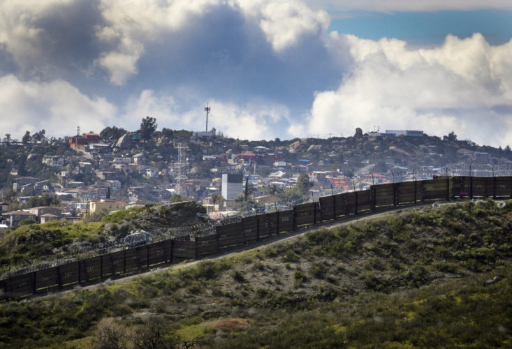 TECATE, CA  03/12/2019: The city of Tecate, Mexico can be seen beyond the border wall. Tecate is a city split between the U.S. and Mexico of the same name. In June 2019, U.S. Customs and Border Protection (CBP) announced they would begin construction of approximately 15 miles of new border wall in place of dilapidated and outdated designs, including the construction of 30-foot tall steel bollards and technology improvements.