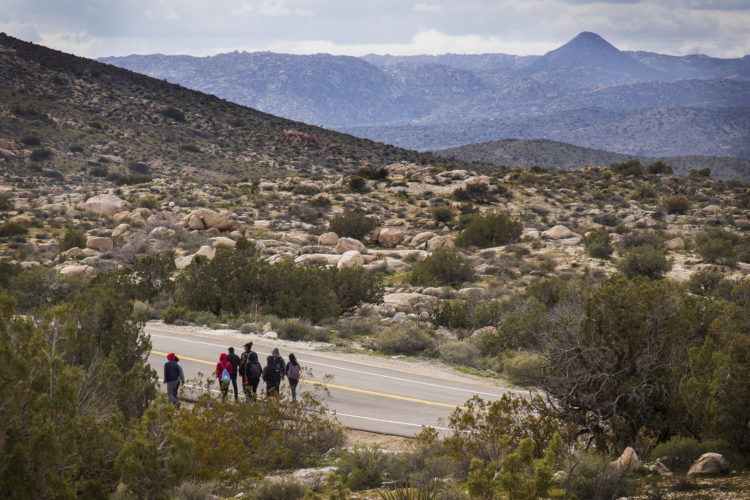 IMPERIAL COUNTY, CA 03-10-2019:  A team of students from University of Utah walk along a roadway in the Imperial Valley near the southern border, where they joined a Border Angels leader Hugo Castro on a  “water drop” in the desert for migrants, where they scattered water containers under sagebrush and along trails that migrants use. “Water drops” are one of Border Angels leading humanitarian efforts. These are hikes to remote areas where they leave water containers for migrants crossing into the U.S.