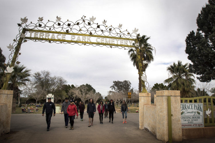 HOLTVILLE, CA 03/10/2019: Hugo Castro of  Border Angels leads a group of students from the University of Utah into the Terrace Park Cemetery in Holtville, CA, where the “Cemetery of the Forgotten” is hidden in a dirt field behind the cemetery. There, the remains of hundreds of unidentified immigrants are buried in a dirt lot behind the . The unidentified migrants died in the Imperial Valley desert or mountains are buried in anonymity, an extreme reflection of the often desperate attempts by people to enter the U.S. where the flow of unauthorized immigrants has been a source of debate for decades. Hugo Castro and a group students from the University of Utah, who were on a tour of the cemetery and were volunteering for the Border Angels organization, fixed crosses that had fallen over, took photos, and said a group prayer.