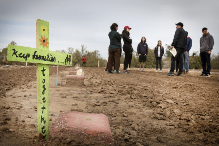HOLTVILLE, CA  03-10-2019: Hugo Castro and the volunteers recite a prayer together before leaving the “Cemetery of the Forgotten,” a Potters Field where the remains of hundreds of unidentified immigrants are buried in a dirt lot behind the Terrace Park Cemetery in Holtville, CA.