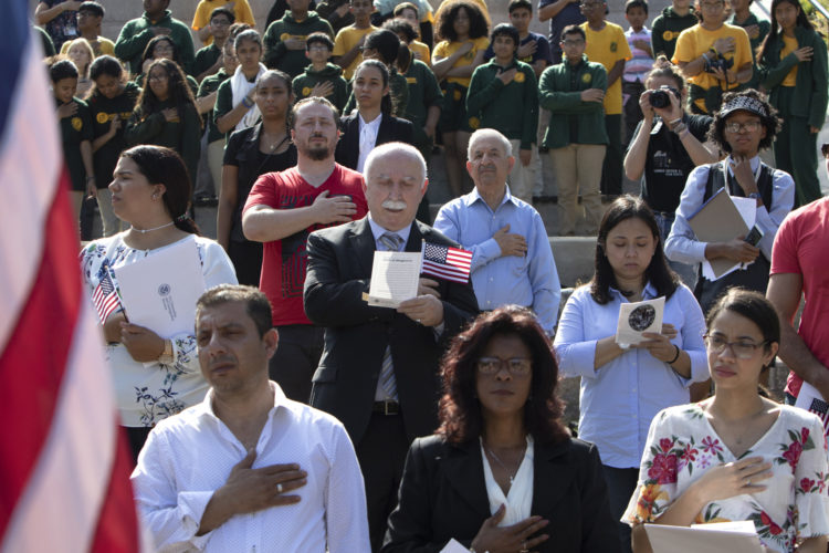 PATERSON, NJ  10-02-2019 NATURALIZATION CEREMONY AT GREAT FALLS:  Ramis Simsek of Wayne places his hand over his heart during the playing of God Bless America during a Naturalization Ceremony at the Paterson Great Falls National Historical Park (NPS). In partnership with U.S. Citizenship and Immigration Services (USCIS), a naturalization ceremony in the park’s new amphitheater was held, where 40 new citizens, mostly residents of Paterson, took the Oath of Allegiance to the United States. Simsek is originally from Turkey.