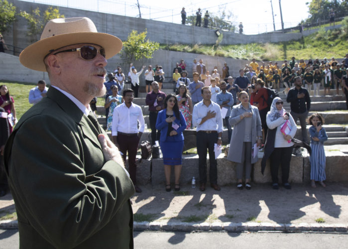 PATERSON, NJ  10-02-2019 NATURALIZATION CEREMONY AT GREAT FALLS:  Darren Boch, Superintendent of the Paterson Great Falls National Historical Park, places his hand over his heart during the playing of God Bless America. The Paterson Great Falls National Historical Park (NPS), in partnership with U.S. Citizenship and Immigration Services (USCIS), held a naturalization ceremony in the park’s new amphitheater where 40 new citizens, mostly residents of Paterson, took the Oath of Allegiance to the United States.