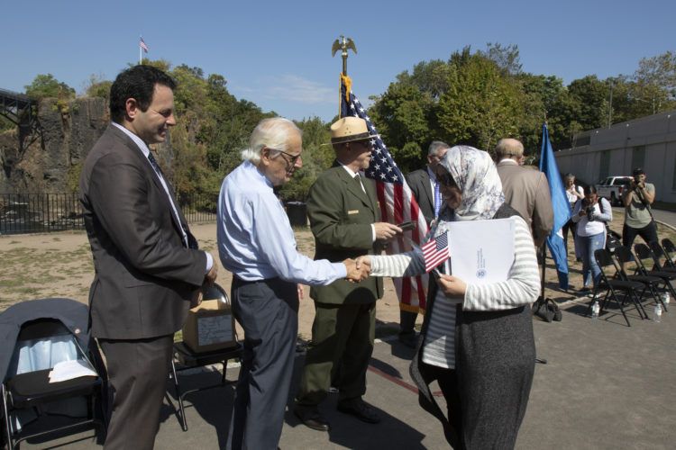PATERSON, NJ  10-02-2019 NATURALIZATION CEREMONY AT GREAT FALLS:  After receiving her Naturalization Certificate, Rachida El Ghyati of Paterson shakes hands with Congressman Bill Pascrell, Jr. and Mayor of Paterson Andre Sayegh. She is from Morocco.
The Paterson Great Falls National Historical Park (NPS), in partnership with U.S. Citizenship and Immigration Services (USCIS), held a naturalization ceremony in the park’s new amphitheater where 40 new citizens, mostly residents of Paterson, took the Oath of Allegiance to the United States.