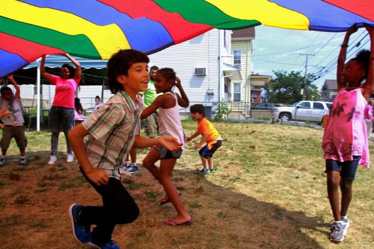 ELIZABETH, NJ  07-26-2016: Mohammed (last name withheld), a 9-year old Syrian boy, runs under a parachute while playing outdoors with other children at the Gateway Family YMCA, Elizabeth Branch Summer Camp. Syrian children recently relocated to New Jersey with their families from war-torn Syria, attended a fun-filled summer camp thanks to sponsorship of two Jewish synagogues,  Bnai Keshet in Montclair and Temple Bnai Abraham in Livingston. At the camp, 16 refugee children ages 5-14 had the opportunity to play games, interact with other children and staff, and use the camp as an opportunity to improve their English and assimilate.