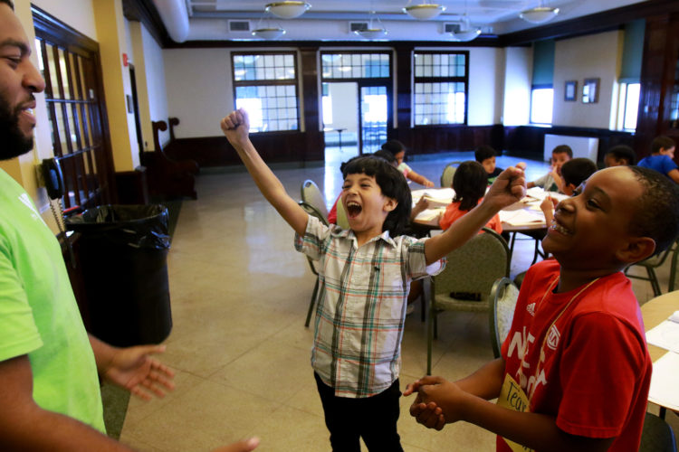 ELIZABETH, NJ  07-26-2016: Summer Camp Director Dante Burgess plays "rock-paper-scissors" with Mohammed, 9, one of the Syrian children, and Jayden, at the Gateway Family YMCA, Elizabeth Branch Summer Camp. Syrian children recently relocated to New Jersey with their families from war-torn Syria, attended a fun-filled summer camp thanks to sponsorship of two Jewish synagogues,  Bnai Keshet in Montclair and Temple Bnai Abraham in Livingston. At the camp, 16 refugee children ages 5-14 had the opportunity to play games, interact with other children and staff, and use the camp as an opportunity to improve their English and assimilate.