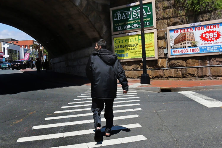 ELIZABETH, NJ   04/30/2016   SYRIAN REFUGEE FAMILIES RESETTLED IN ELIZABETH:  Fadel El Radi walks along Broad Street in Elizabeth near the train overpass. Al Radi is a Syrian refugee, his family was related in Elizabeth last year. Unable to speak English or secure steady work, Al Radi and his family are struggling to adjust to their new life in the United States. Radi fled his home in Daraa, Syria, with his wife and kids after it was badly damaged by aerial bombings in which wife Maryam was injured. After his son Mohammed, 7, became ill, they fled to Jordan where they were remained for 3-years before being resettled in Elizabeth by the IRC, they have 4 children.