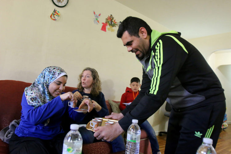 ELIZABETH, NJ   04/03/2016   SYRIAN REFUGEE FAMILIES RESETTLED IN ELIZABETH:   Mohammed Zakkour serves coffee to Kate McCaffrey of Bnai Keshet Synagogue in Montclair, and Salma Hassan, an MSU student who volunteers to tutor Syrian children and act as an interpreter, in the family's apartment in Elizabeth where the IRC resettled them. The Zakkour's fled their home in Homs, Syria, after it became unsafe due to aerial bombings.