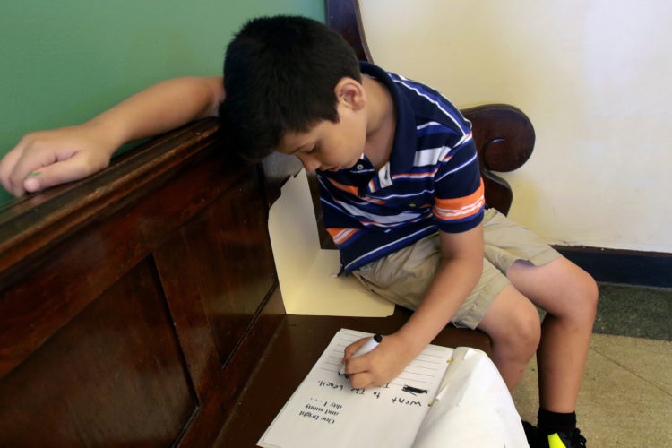 ELIZABETH, NJ  07-26-2016:  Zain, 7, one of the Syrian children writes in English in his coloring book during an arts and crafts activity at the Gateway Family YMCA, Elizabeth Branch Summer Camp. Syrian children recently relocated to New Jersey with their families from war-torn Syria, attended a fun-filled summer camp thanks to sponsorship of two Jewish synagogues,  Bnai Keshet in Montclair and Temple Bnai Abraham in Livingston. At the camp, 16 refugee children ages 5-14 had the opportunity to play games, interact with other children and staff, and use the camp as an opportunity to improve their English and assimilate.