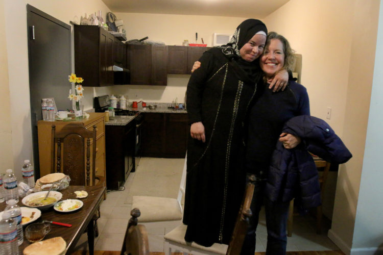 ELIZABETH, NJ   04/03/2016   SYRIAN REFUGEE FAMILIES RESETTLED IN ELIZABETH:   Maryam Al Radi jokingly stands on a chair because she is short, as she hugs her new friend Kate McCaffrey  from Bnai Keshet Synagogue. Bnai Keshet has "adopted" the AL Radi's, providing friendship and assistance in helping the family get acclimated to their new life in the US.