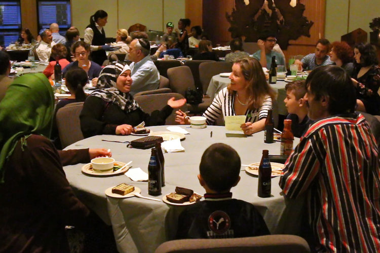 MONTCLAIR, NJ   04/23/2016: Kate McCaffrey of the Bnai Keshet Synagogue, talks with Maryam Al Radi at Passover Seder. The two have become very close in the few months they have known each other, despite cultural and language differences. The Bnai Keshet congregation invited the Al Radi family, who are Muslim, to their community Seder for Passover. The Bnai Keshet congregation of Montclair has informally adopted the Al Radi family, who are Syrian refugees recently relocated in Elizabeth last year. They fled their home in Daraa, Syria, after it was badly damaged by aerial bombings in which wife Maryam was injured. After their son Mohammed, 7, became ill, they fled to Jordan where they were remained for 3-years before being resettled in Elizabeth by the IRC, they have 4 children.