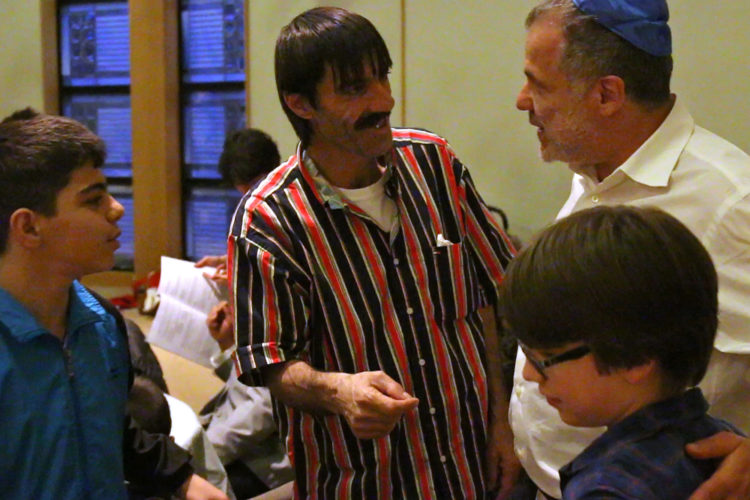 MONTCLAIR, NJ   04/23/2016   SYRIAN REFUGEE FAMILIES RESETTLED IN ELIZABETH/ COMMUNITY SEDER:  Lee Siegel and his son Julian, 9, of the Bnai Keshet Synagogue welcome Fadel Al Radi and his son Mohammed age 13. The Bnai Keshet congregation invited the Al Radi family, who are Muslim, to their community Seder for Passover. The Bnai Keshet congregation of Montclair has informally adopted the Al Radi family, who are Syrian refugees recently relocated in Elizabeth last year. They fled their home in Daraa, Syria, after it was badly damaged by aerial bombings in which wife Maryam was injured. After their son Mohammed, 7, became ill, they fled to Jordan where they were remained for 3-years before being resettled in Elizabeth by the IRC, they have 4 children.