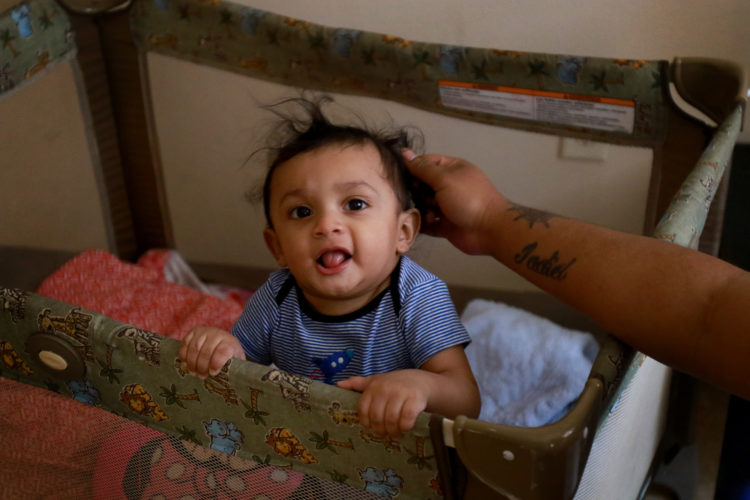 NEWARK, NJ  07-19-2018: Kasandra Serrano, 21, plays with her 9-month old son Ismael in the apartment complex where she is living with her mother and sisters. Serrano's fiancé Daniel Castro, 28, was taken into custody by Newark Police in June 2018 and turned over to ICE despite Newark's Sanctuary City policy. Castro, who is undocumented but has no criminal record and did not commit any offense the evening of his arrest, was falsely arrested, and Newark Police admit they made a mistake in violating the city's own Sanctuary City policy. On the night of his arrest, Castro was returning from shopping for baby formula when he was stopped by police and reluctantly gave his name when they arrested him for an outstanding ICE warrant from many years ago for which he said he was never notified. After many months of being held at the Elizabeth Detention Center (ICE) he was deported to his native Nicaragua where he currently awaiting a status hearing in New Jersey. The couple has a 9-month old baby boy, Ismael, and since Danny's arrest Serrano has been living with her mother, sisters, and their young children in a small apartment in Newark, and says she cannot support herself and the baby without government and family assistance.