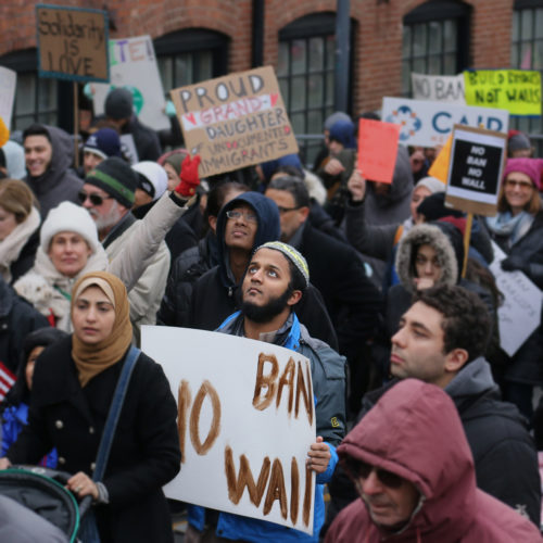 PATERSON, NY  02/05/2017: A protester looks to the sky as he carries a sign during the “March for Peace and Decency” in downtown Paterson. The crowd of roughly 2,000 included scores of religious leaders, elected officials, activists, and local families who  marched through downtown before gathering at the Great Falls National Park. Senators Cory Booker and Robert Menendez, and Congressman Bill Pascrell, Jr. also joined the march. Rally organizers said they hoped to unite Christian, Jewish, Muslim, and other religious leaders, “in a peaceful manner to demand justice for all.”