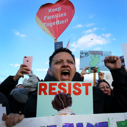 ELIZABETH, NJ  01-29-2016: A protester holds a resist sign outside the Elizabeth immigration detention facility (ICE), where roughly 2,000 protesters marched called for an end to President Donald Trump's executive order on immigration. The executive order stops the processing of Syrian refugees, suspends the broader refugee program, calls for a more intense vetting system, and imposes a three-month ban on immigration from Iraq, Syria, Iran, Sudan, Libya, Somalia and Yemen.The measure was later blocked by a federal judge.
