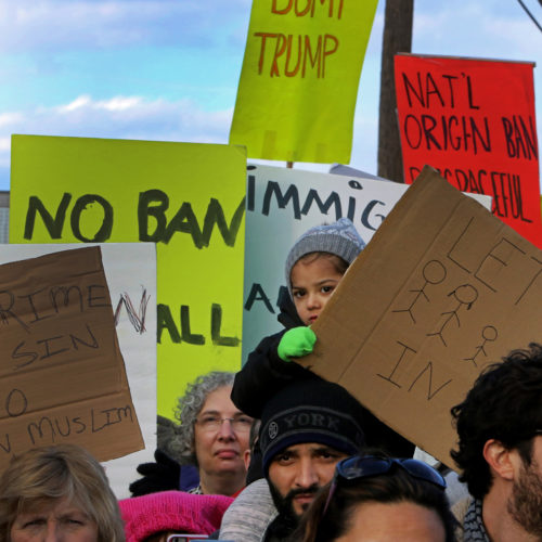 ELIZABETH, NJ  01/29/2016: Ayat Modan, 3, sits on the shoulders of her father Nayeem at an immigration-rights rally outside the Elizabeth immigration detention facility (ICE), where roughly 2,000 protesters marched, calling for an end to President Donald Trump's executive order on immigration. The executive order stops the processing of Syrian refugees, suspends the broader refugee program, calls for a more intense vetting system, and imposes a three-month ban on immigration from Iraq, Syria, Iran, Sudan, Libya, Somalia and Yemen.The measure was later blocked by a federal judge.