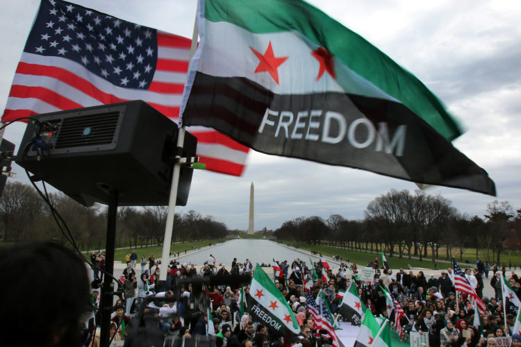 WASHINGTON D.C.  03/20/2016: Hundreds take part in the “March for Syrian Freedom” rally in Washington DC on the National Mall, marking the 5th Anniversary of the Syrian Revolution. Along with the flags of the U.S. the protesters carried Syrian Revolution flags, which are different that the Syrian national flag.

Five years after it began, Syria’s civil war is among the worst humanitarian crisis of our time. The civil unrest has killed more than 220,000 of its citizens, and it has been estimated that over 11 million people have been forced to leave their homes. Bombings have destroyed cities, human rights violations are widespread, and basic human necessities like food, housing, and medical care are sparse. Roughly half of Syria’s population has fled to either neighboring countries or to Europe, many risking their lives in hopes of finding acceptance and opportunity abroad, while hundreds of thousands remain stranded in refugee camps across the Middle East, Europe, and the Mediterranean region prompting rights groups to accuse the international community of failing Syria.
