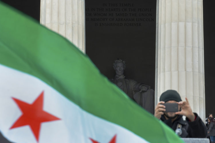 PATERSON, NJ   03/20/2016: Mohamed Khairullah takes snaps a photo during the “March for Syrian Freedom” rally under the watchful eye of Abe Lincoln the at Lincoln Memorial. Khairullah, the mayor of Prospect Park, NJ and a refugee from Syria, escorted a group from Passaic County to participate in the rally commemorating the 5th anniversary of when the conflict began as an anti-government uprising with protesters taking to the streets on March 15, 2011, brings  attention to the global humanitarian crisis and raise money to aid Syrian refugees worldwide. The program included an interfaith conference at the Lincoln memorial, followed by a march to the White House.