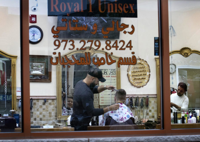 SOUTH PATERSON, NJ  05-04-19: Barbers cut hair at the Royal 1 Salon on Main Street in South Paterson, a bustling neighborhood in Passaic County where many of the stores and shops cater to Arab and Turks, evidenced by the signs in English and Arabic.
