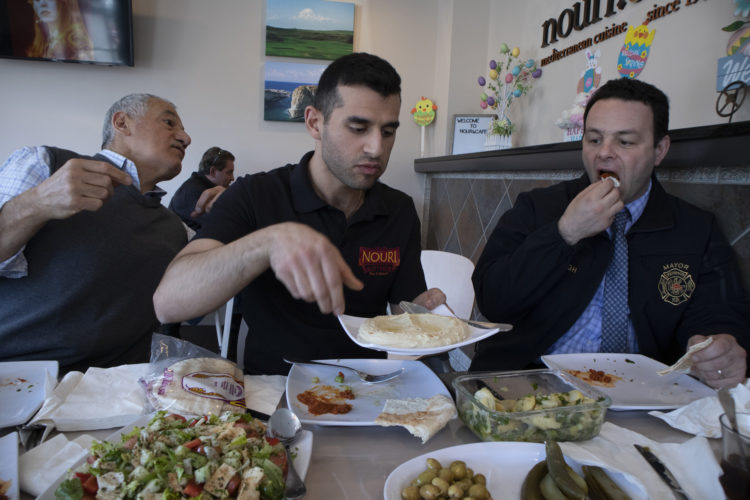 04-17-19 PATERSON, NJ:  Andre Sayegh, the mayor of Paterson, NJ, right, eats with Albert and George Noury (note their name and the restaurant name are spelled differently) who own the Nouri.Cafe on Main Street in South Paterson. Sayegh is the first Arab-American to lead the city, which has had a long-thriving Middle Eastern immigrant community in the southern district of the city known as South Paterson. Sayegh’s was born to a Syrian mother and a Lebanese father, and is Christian, was a longtime city councilman and was elected mayor in 2018.
