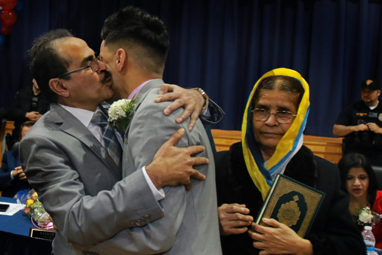 PROSPECT PARK, NJ  01-05-2019: Intashan Chowdhury embraces his father Golam after he was sworn-in as Prospect Park's new borough administrator, as his grandmother Dilara looks on at right. the 22-year old is believed to be the youngest town manager in New Jersey history, if not the nation, and is first of Bengali descent. He is a Rutgers graduate student, and was sworn-in by his long-time mentor, Mayor Mohamed T. Khairullah, a teacher of his in high school. His grandmother is the eldest relative living and is clutching the Quran for a historic occasion.
